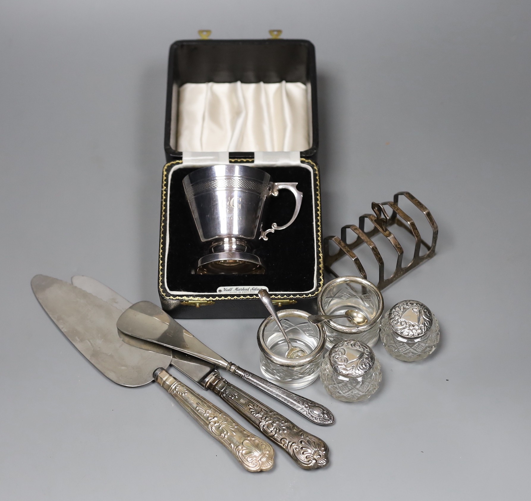 An Art Deco design silver christening can, Birmingham 1961, with fitted case, a toastrack and seven silver mounted items, 5 oz of weighable silver